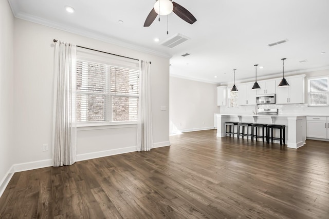 unfurnished living room featuring ornamental molding, dark wood finished floors, and visible vents