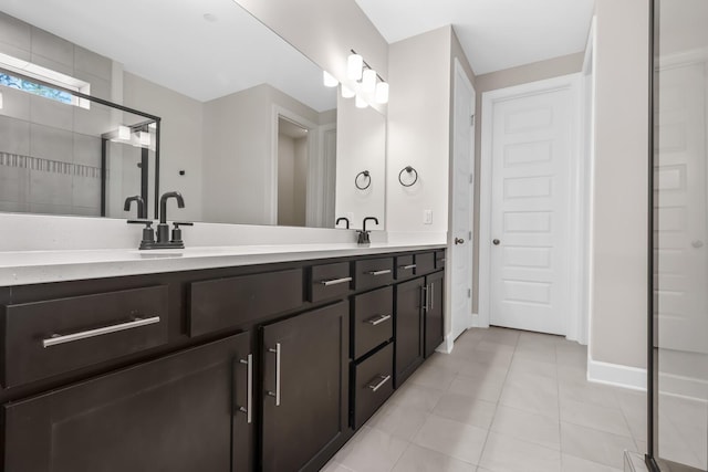 full bathroom with baseboards, double vanity, and tile patterned floors