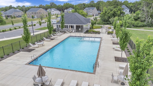 pool with a yard, a patio area, fence, and a residential view