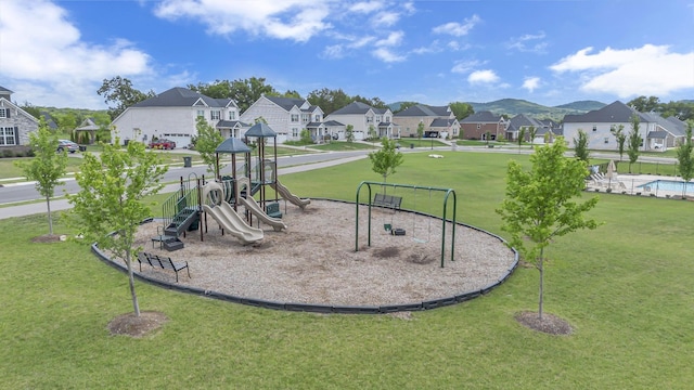 view of jungle gym featuring a yard and a residential view