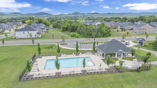 pool with fence private yard, a patio area, a residential view, and a mountain view