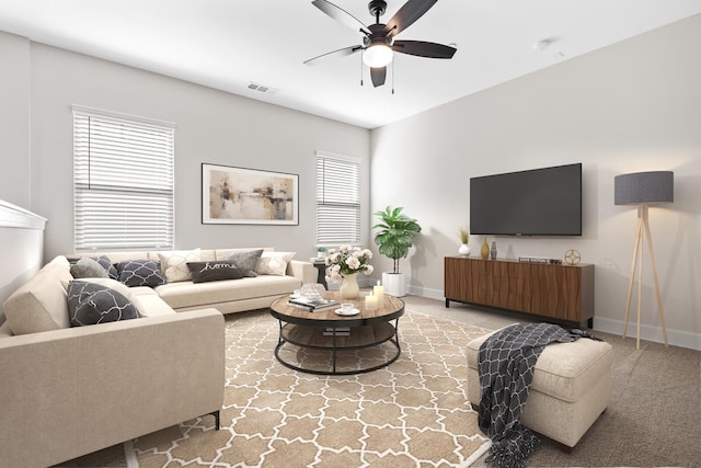 living area with light carpet, ceiling fan, visible vents, and baseboards