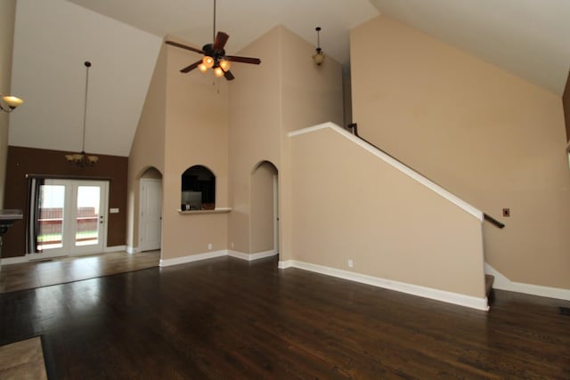 unfurnished living room with dark hardwood / wood-style flooring, ceiling fan with notable chandelier, and high vaulted ceiling