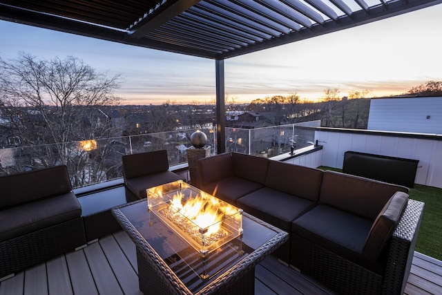 deck at dusk featuring an outdoor living space with a fire pit