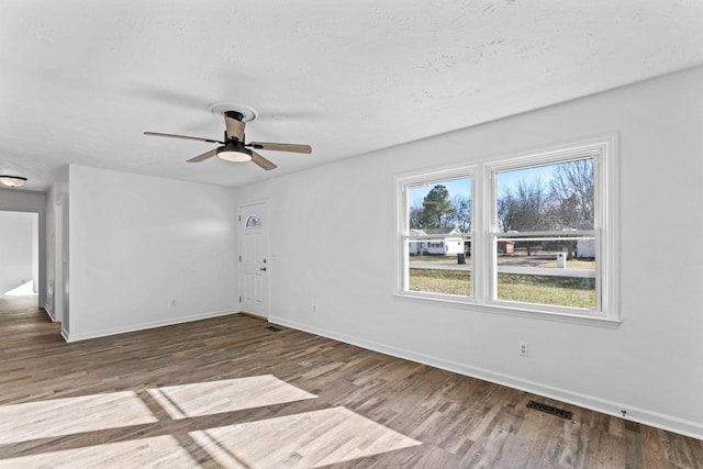 empty room featuring ceiling fan, a textured ceiling, and hardwood / wood-style flooring