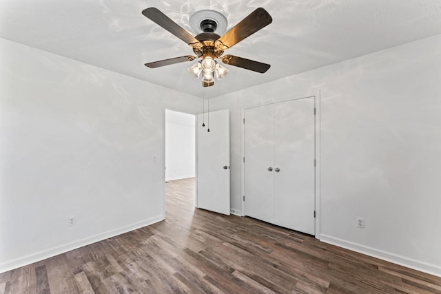 unfurnished bedroom with ceiling fan, wood-type flooring, and a closet