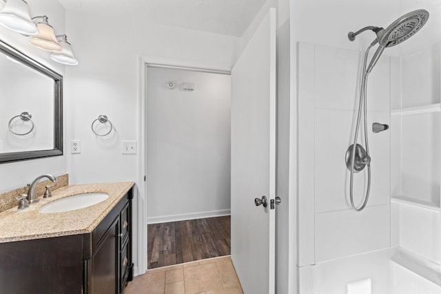 bathroom with wood-type flooring, walk in shower, and vanity