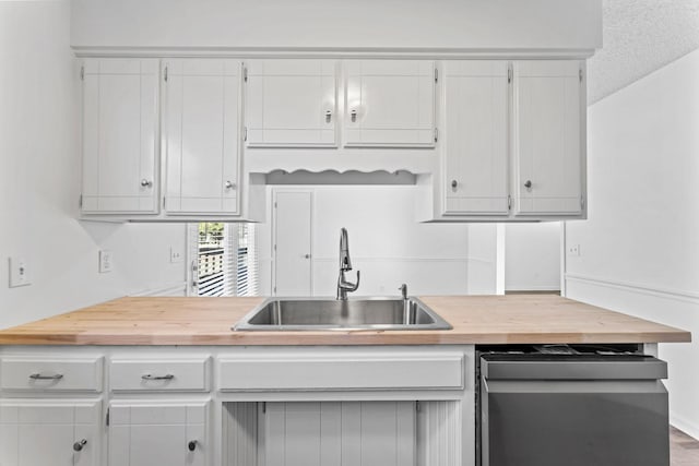 kitchen with sink, a textured ceiling, white cabinets, and dishwasher