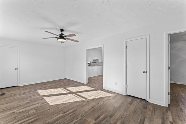 unfurnished bedroom with ceiling fan, dark wood-type flooring, and a textured ceiling