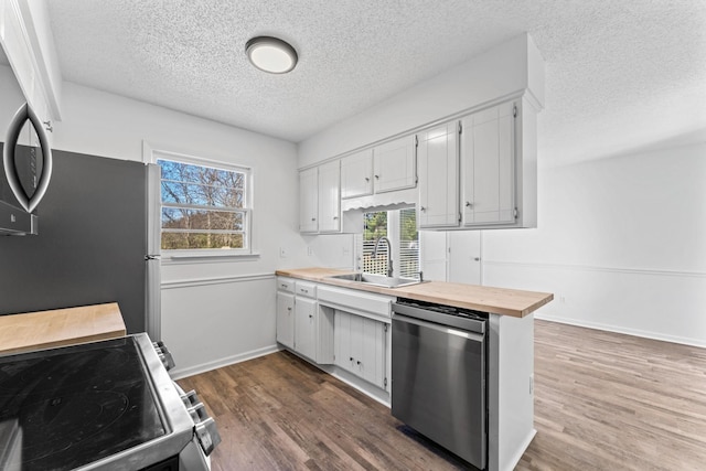 kitchen featuring sink, white cabinetry, appliances with stainless steel finishes, and dark hardwood / wood-style floors