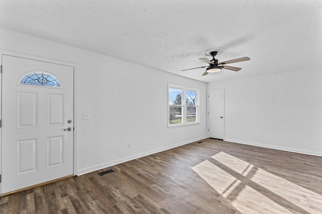 entrance foyer featuring a textured ceiling, ceiling fan, and dark hardwood / wood-style flooring