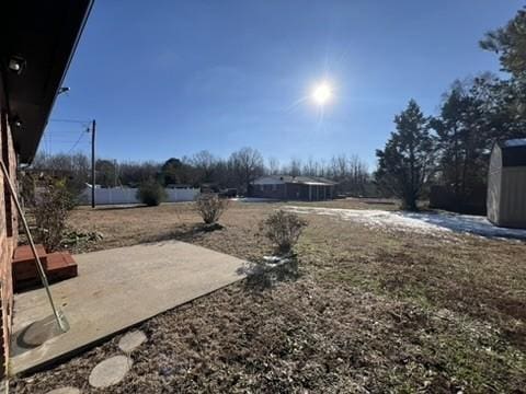 view of yard with a storage unit and a patio