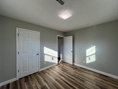 unfurnished bedroom featuring dark hardwood / wood-style flooring