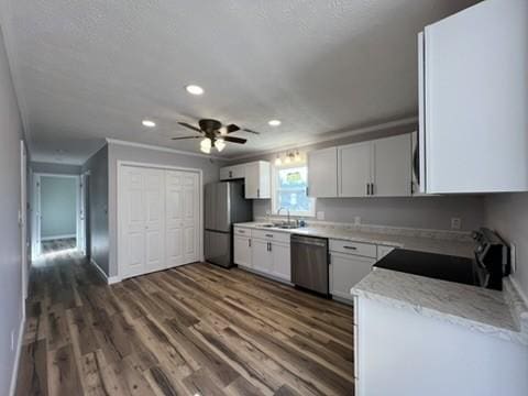 kitchen with appliances with stainless steel finishes, ceiling fan, sink, white cabinets, and dark hardwood / wood-style floors