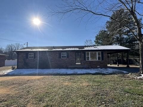 back of property featuring a lawn and a carport