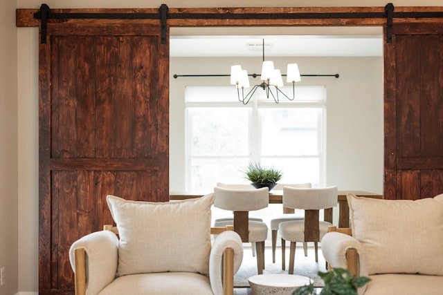 sitting room with a barn door and an inviting chandelier