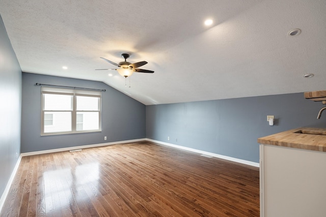 bonus room with dark hardwood / wood-style flooring, ceiling fan, lofted ceiling, and sink