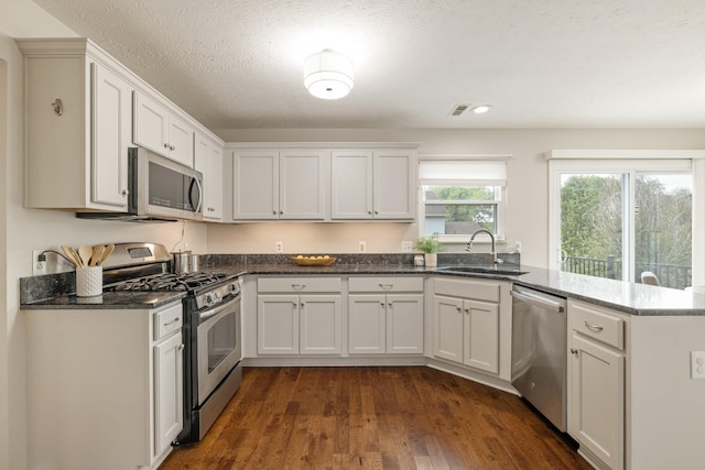 kitchen featuring white cabinets, sink, appliances with stainless steel finishes, and a textured ceiling