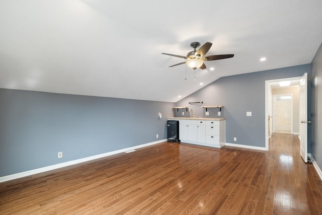 unfurnished living room with ceiling fan, vaulted ceiling, and hardwood / wood-style flooring