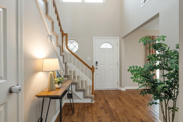 foyer entrance featuring dark wood-type flooring and a high ceiling