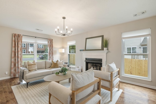 living room with a notable chandelier and light wood-type flooring