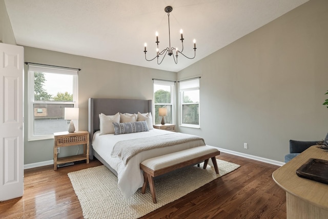 bedroom featuring hardwood / wood-style floors, vaulted ceiling, and an inviting chandelier