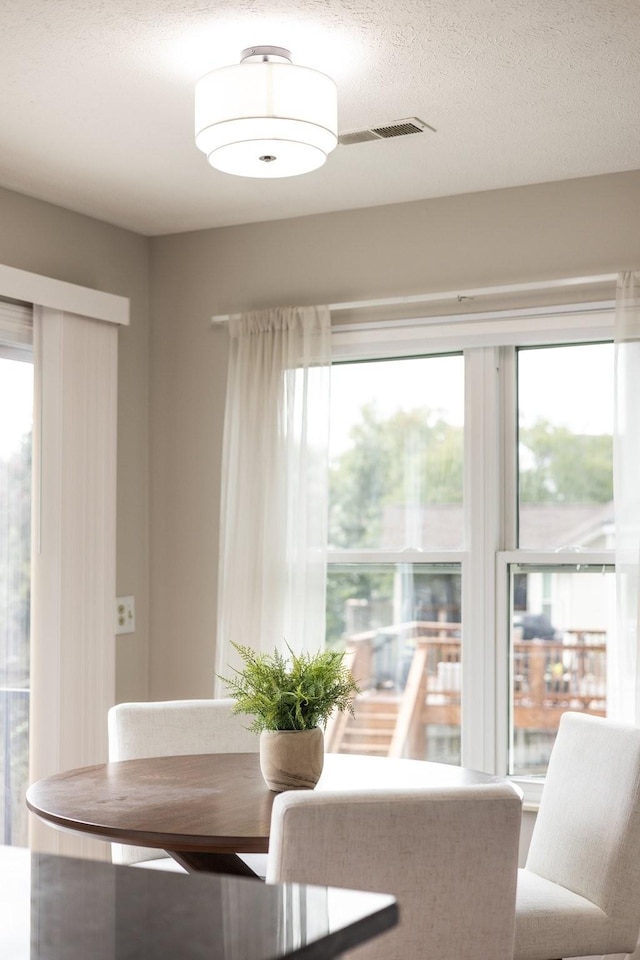 unfurnished dining area with a textured ceiling