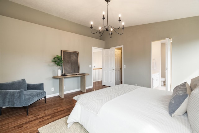 bedroom with a chandelier, hardwood / wood-style floors, vaulted ceiling, and ensuite bath