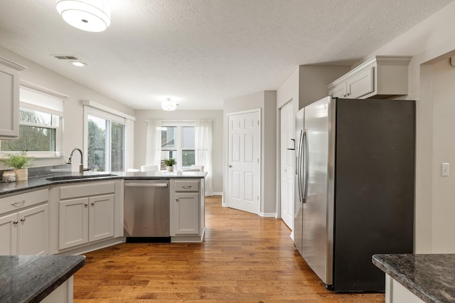 kitchen featuring white cabinets, sink, appliances with stainless steel finishes, and a textured ceiling