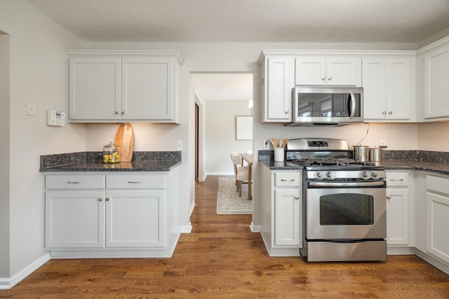 kitchen featuring wood-type flooring, white cabinetry, and stainless steel appliances