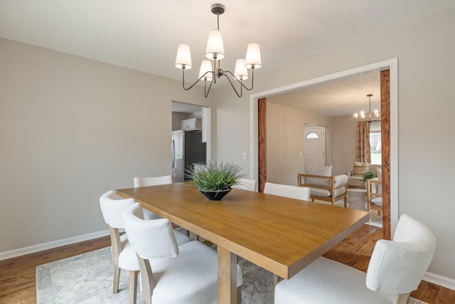 dining room with hardwood / wood-style flooring and a notable chandelier