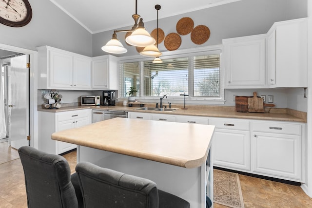 kitchen featuring white cabinets, appliances with stainless steel finishes, sink, and hanging light fixtures