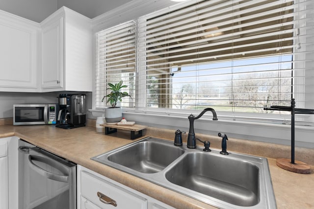 kitchen featuring a wealth of natural light, sink, white cabinets, and stainless steel appliances