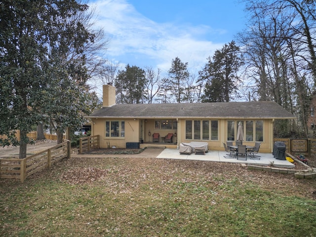 back of house featuring a patio and a lawn