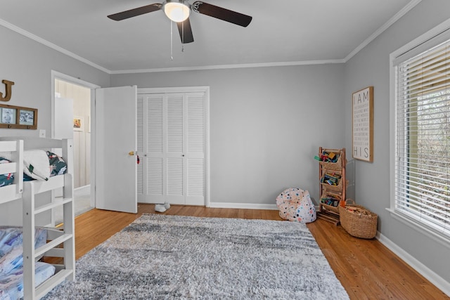 bedroom featuring ceiling fan, a closet, light hardwood / wood-style floors, and ornamental molding