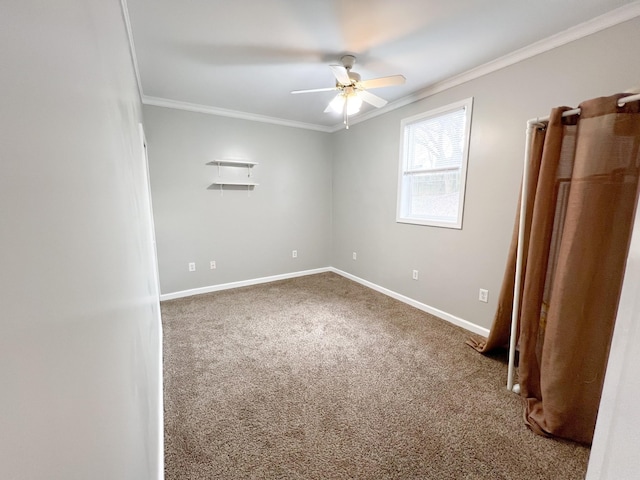 carpeted spare room featuring a ceiling fan, baseboards, and crown molding