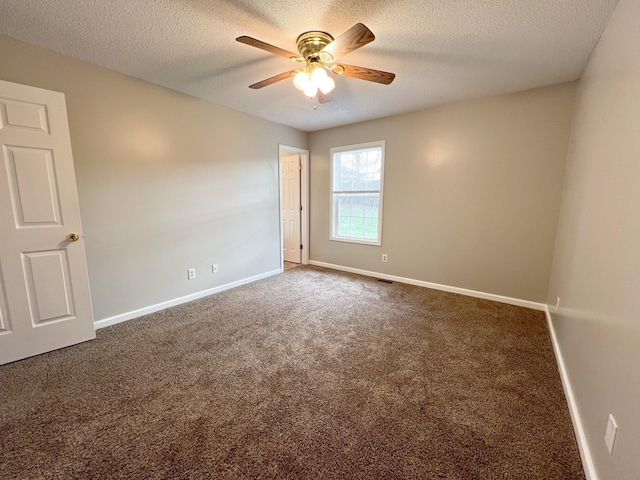 spare room with a textured ceiling, carpet, a ceiling fan, and baseboards