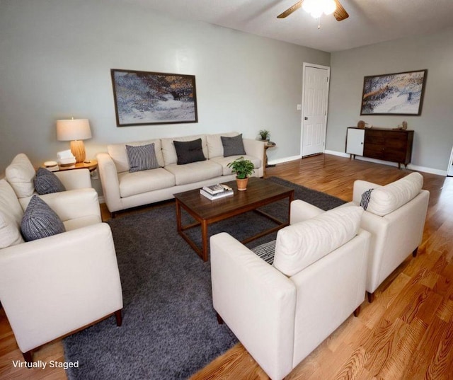 living area with ceiling fan, baseboards, and wood finished floors