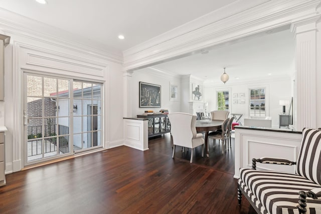 dining room with ornamental molding, a healthy amount of sunlight, dark hardwood / wood-style floors, and decorative columns