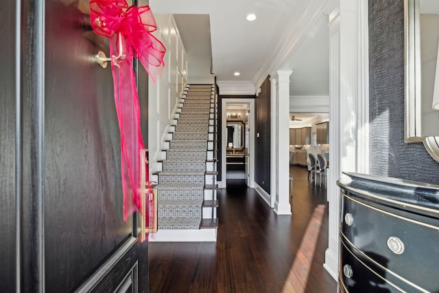 entryway featuring dark hardwood / wood-style floors, crown molding, and ornate columns