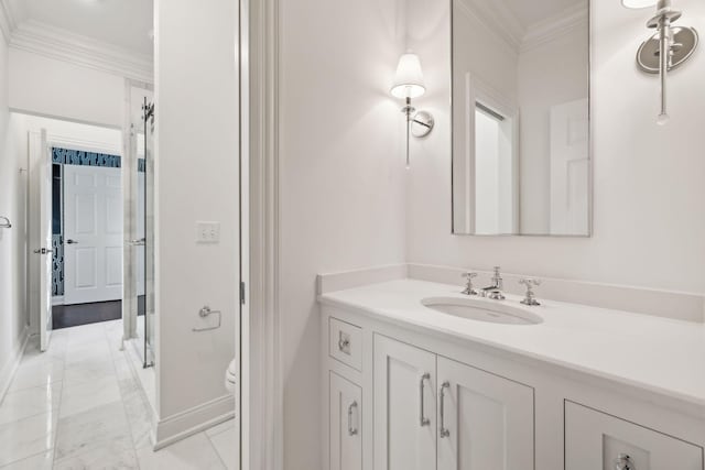 bathroom with toilet, vanity, and ornamental molding