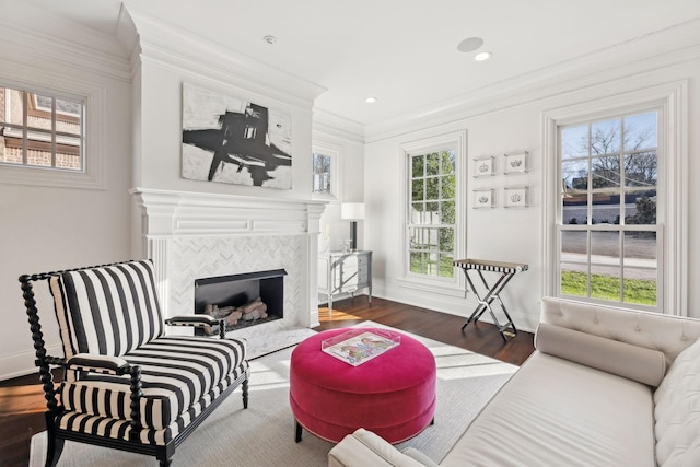 living room with dark hardwood / wood-style flooring, ornamental molding, plenty of natural light, and a tile fireplace