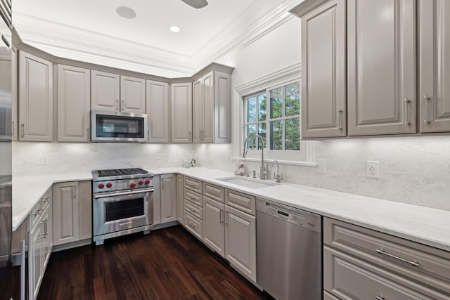 kitchen with backsplash, dark hardwood / wood-style floors, sink, appliances with stainless steel finishes, and gray cabinetry