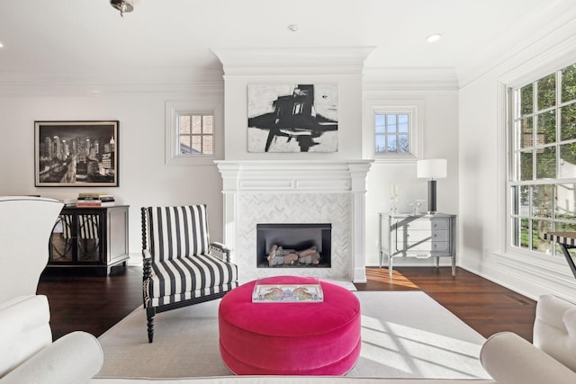 living room featuring dark hardwood / wood-style flooring, ornamental molding, and a tiled fireplace