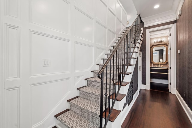 staircase with crown molding and hardwood / wood-style flooring