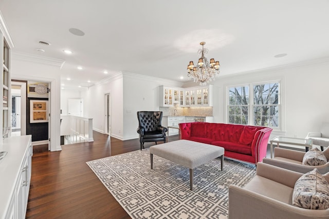 living room featuring dark hardwood / wood-style flooring, sink, ornamental molding, and a chandelier