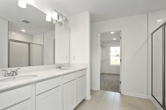 bathroom featuring tile patterned flooring, vanity, and a shower with shower door