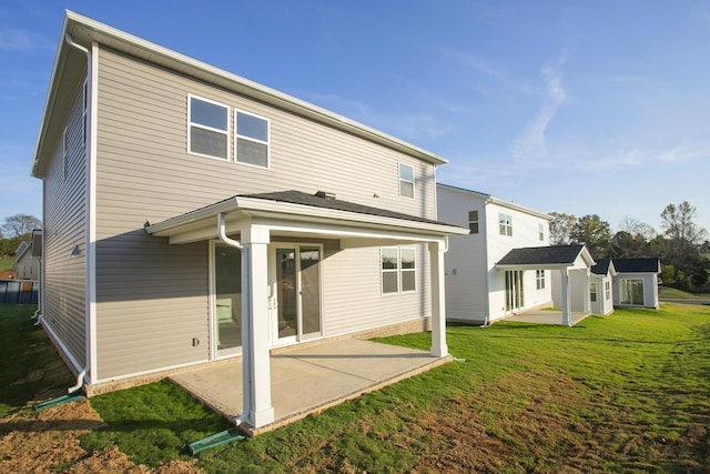 back of house with a lawn and a patio