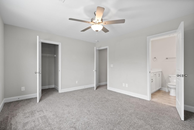 unfurnished bedroom with ceiling fan, light carpet, connected bathroom, and a closet