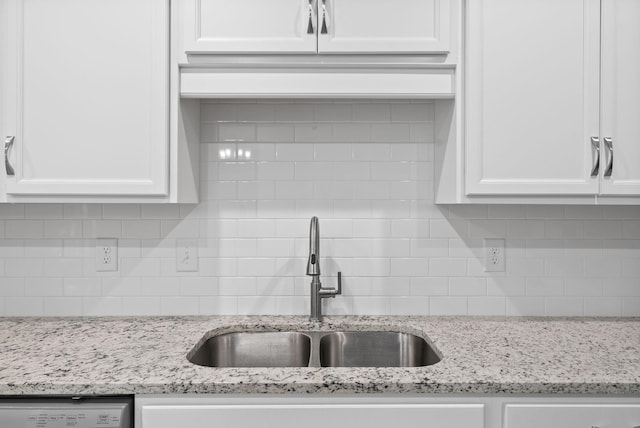 kitchen featuring decorative backsplash, light stone counters, white cabinetry, and sink